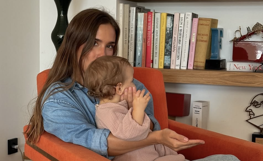 María Pombo, con una estantería con libros a su espalda.