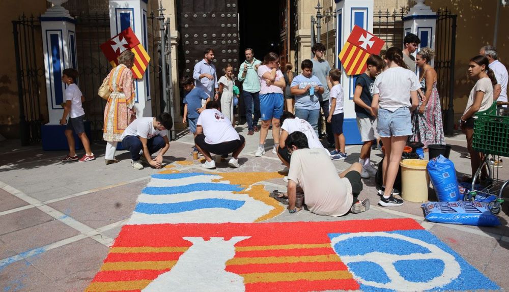 Un grupo de jóvenes, terminando la alfombra justo en la puerta de acceso a la basílica. 