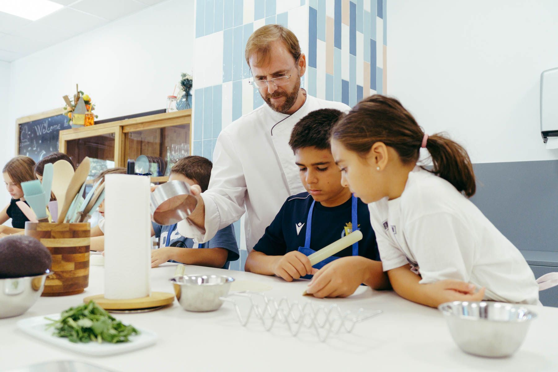 Juan Ramón, el chef de Cookery, con dos de los pequeños alumnos. Juan Ramón, el chef de Cookery, con dos de los pequeños alumnos.