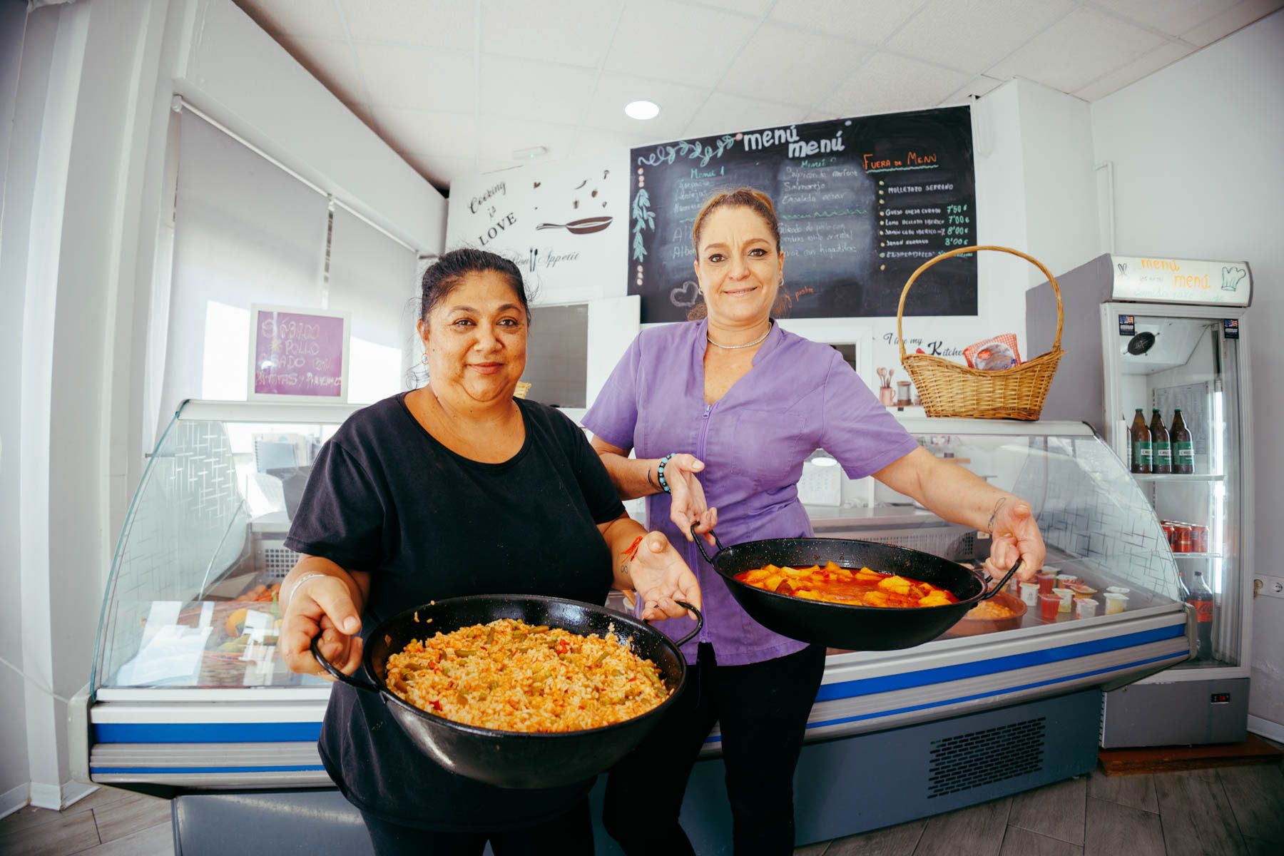 Inma Arriaza, junto a Malena Medrano, portando algunos de sus guisos.