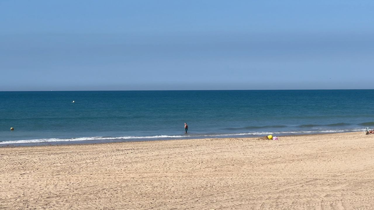 Una persona disfruta de un baño en la playa de la Victoria de Cádiz.