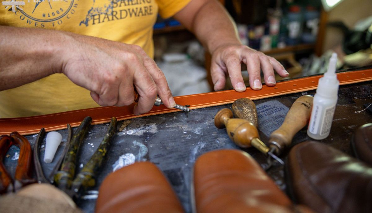 El zapatero fabrica un cinturón desde cero.