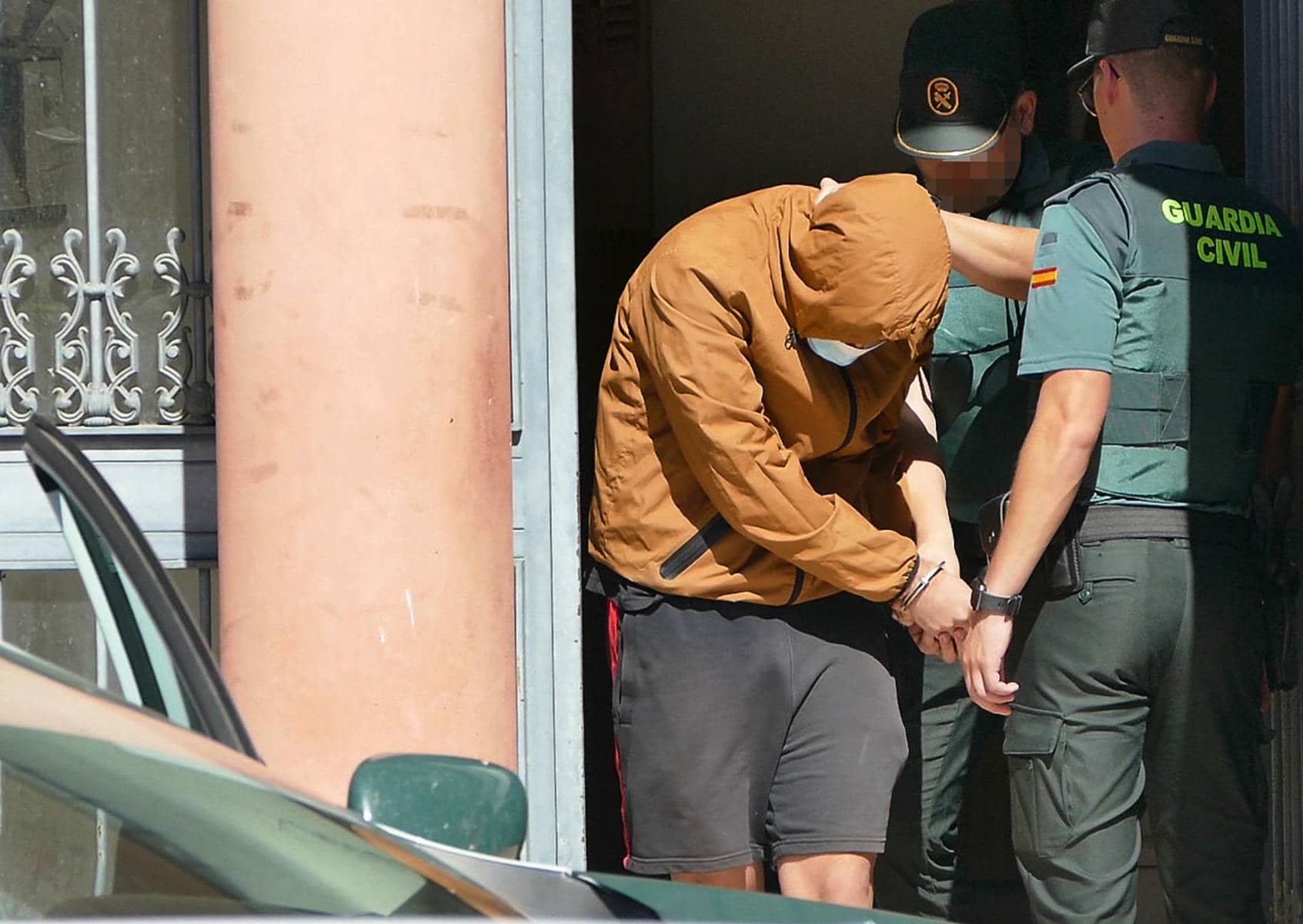 Agentes de la Guardia Civil trasladan al detenido tras la reconstrucción de los hechos en el domicilio en Brenes.