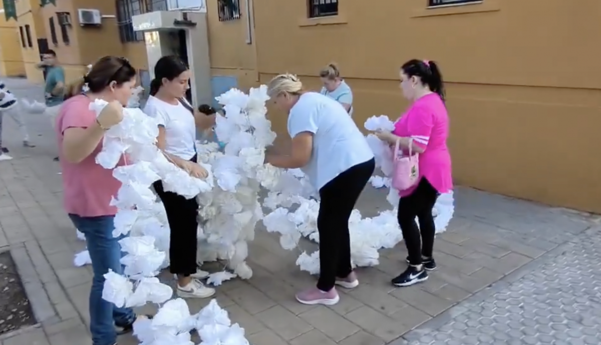 Vecinas de Las Letanías engalanando la calle por donde pasará la Esperanza. 