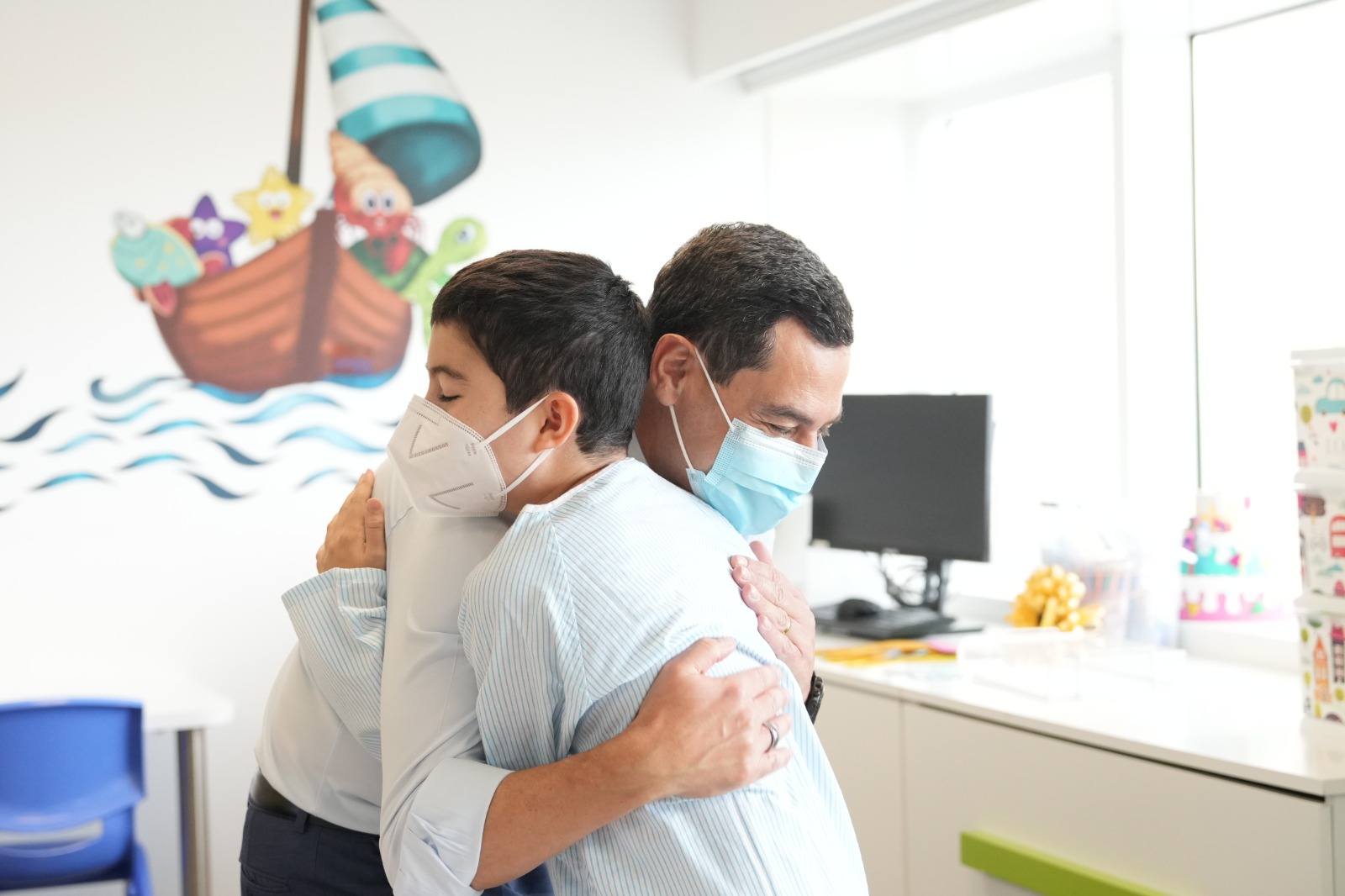 Moreno abrazo a un niño ingresado que continúa sus estudios en las aulas hospitalarias del Hospital Materno Infantil Princesa Leonor, en el Hospital Universitario Torrecárdenas, en Almería.