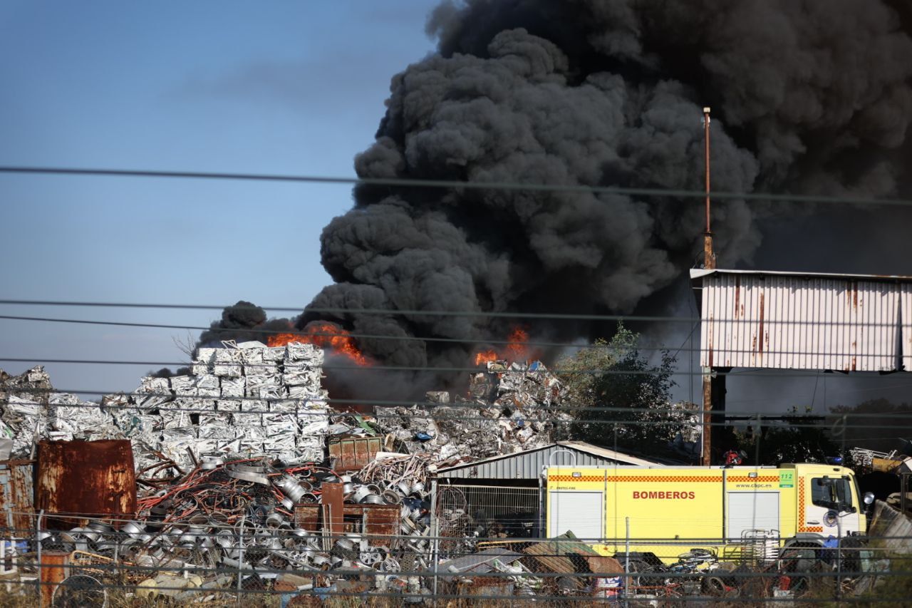 Las llamas desatadas por el incendio en el desguace del polígono El Portal de Jerez.
