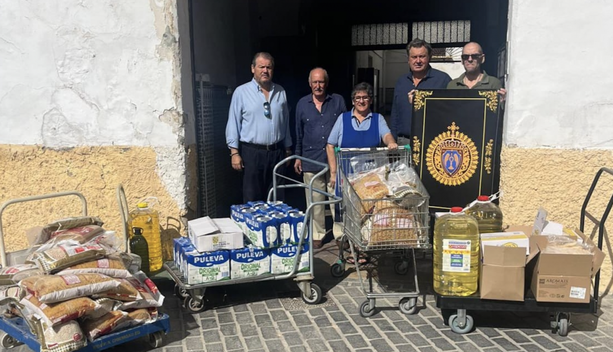 Cofrades del Desconsuelo en el comedor depositando una entrega de alimentos. 