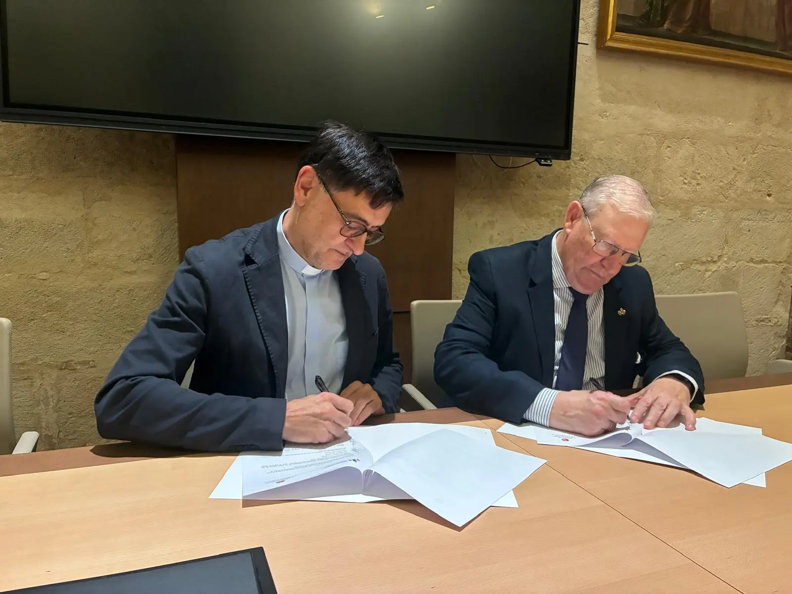 El deán de la Catedral y el presidente del Consejo en la firma del convenio.