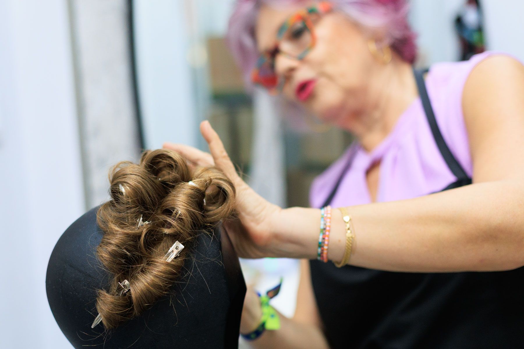 Iluminada estilizando una de las pelucas que ofrece.
