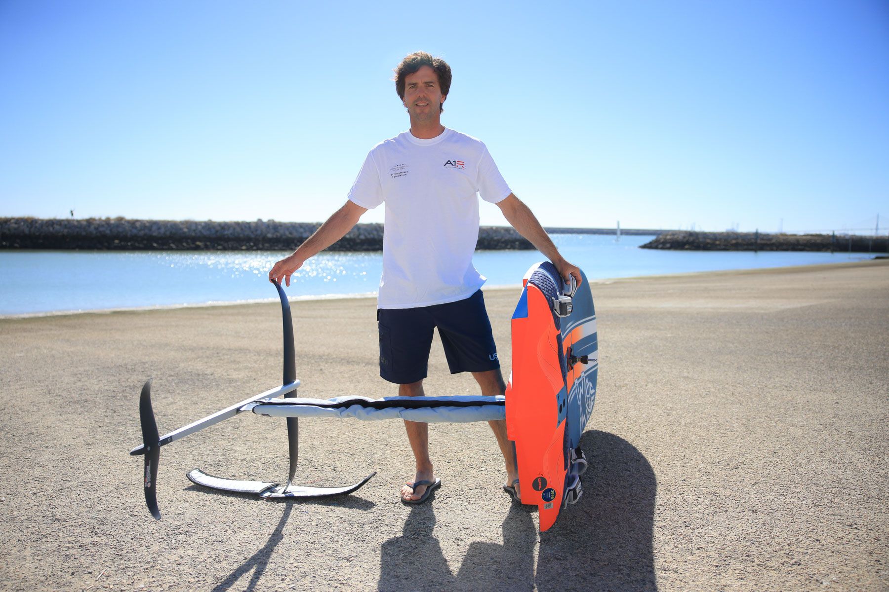 El entrenador olímpico Juanma Moreno con su tabla de wind foil en El Puerto.