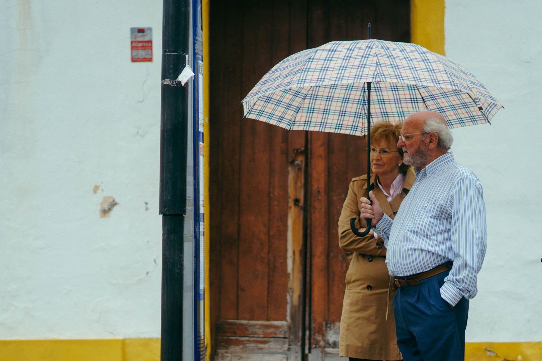 Dos personas bajo un paraguas se refugian de la lluvia.