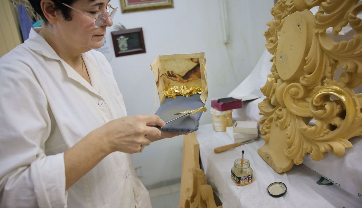 Felisa García aplicando el dorado a una cartela de un paso.