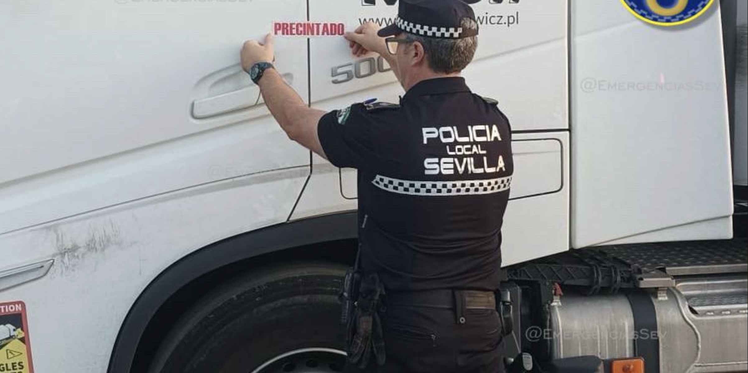Un agente de la Policía Local precintando el camión.   FOTO: EMERGENCIAS SEVILLA