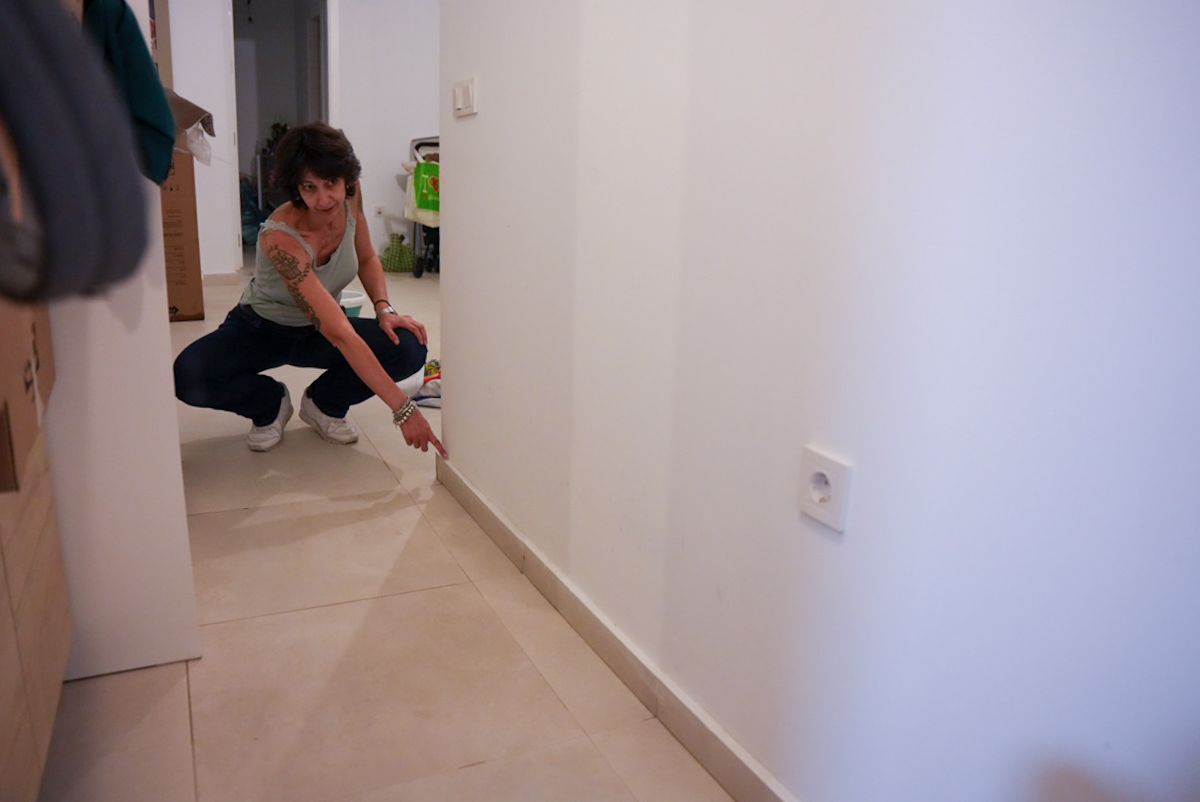 Una vecina señalando la altura donde llegó el agua tras la inundación.