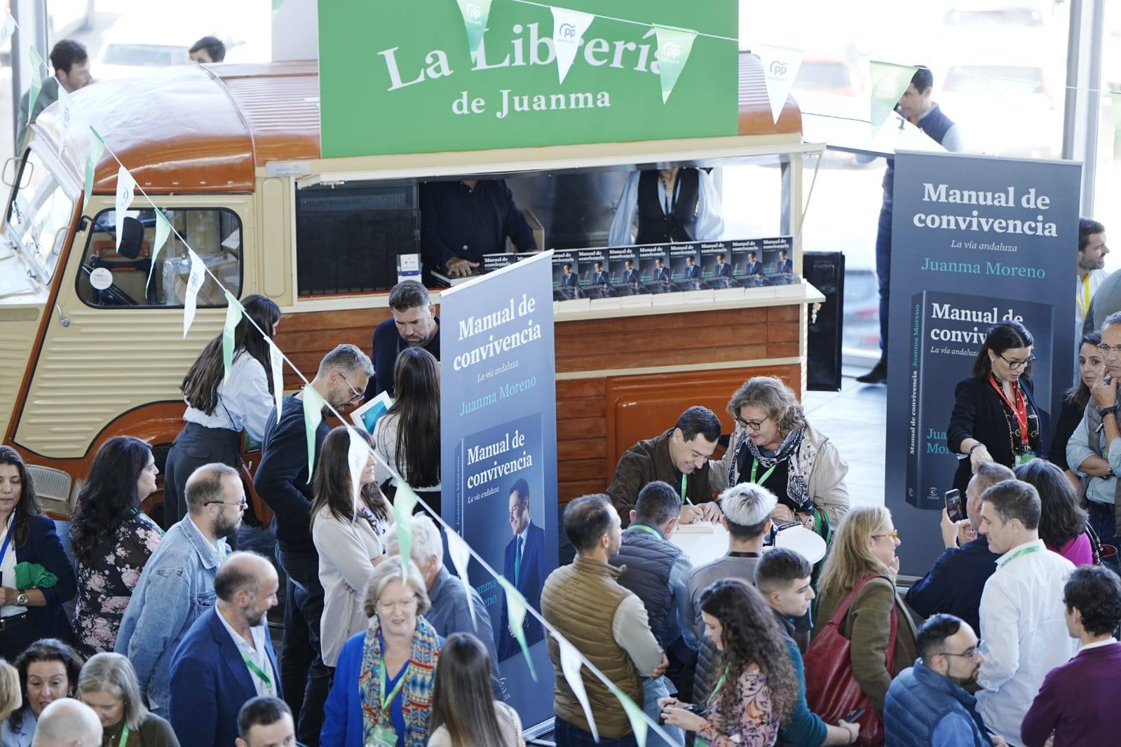 Juanma Moreno firmando libros en el congreso del PP.