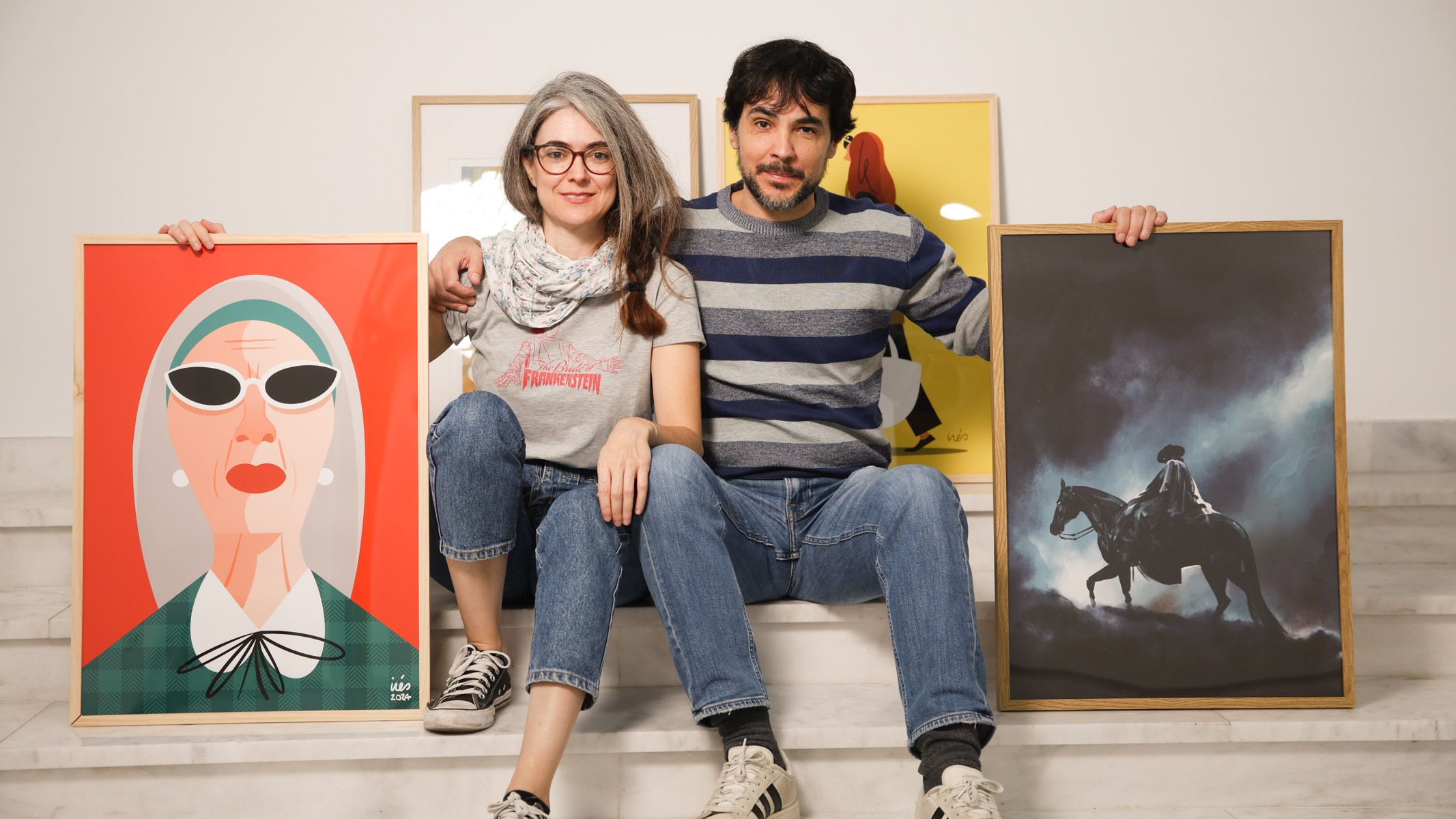 Los ilustradores Inés Jiménez y Alberto Belmonte, con algunas de las obras de la exposición.