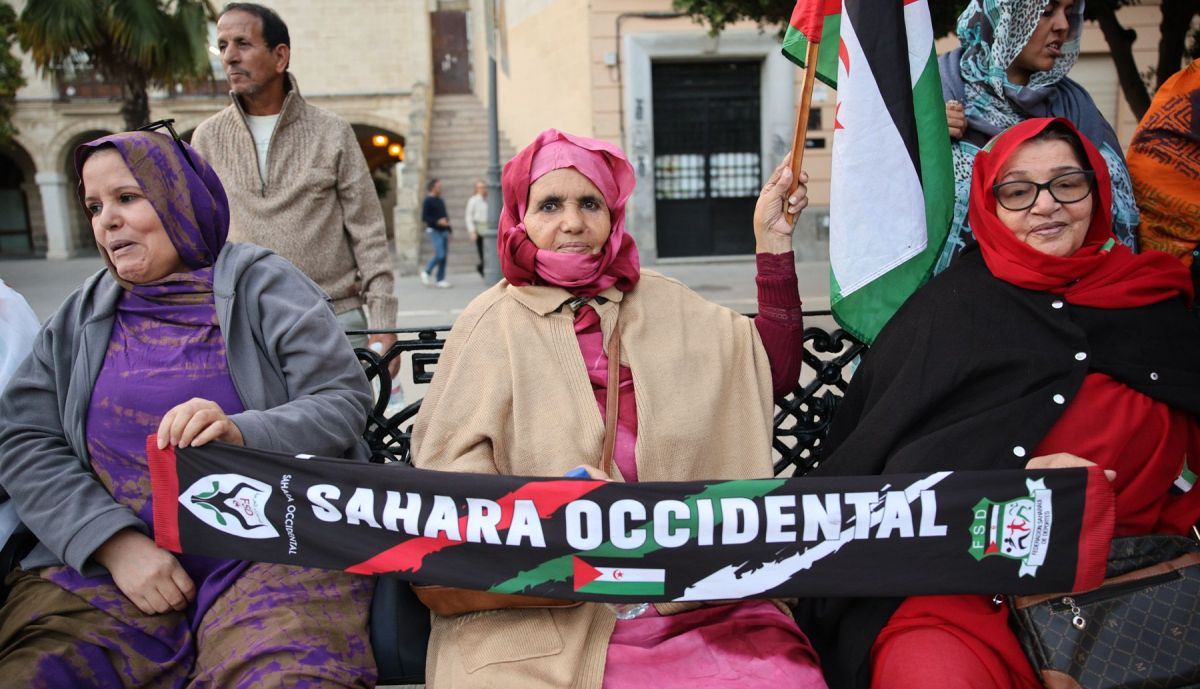 Varias mujeres, con una bufanda de Sáhara Occidental, en un banco del Arenal.