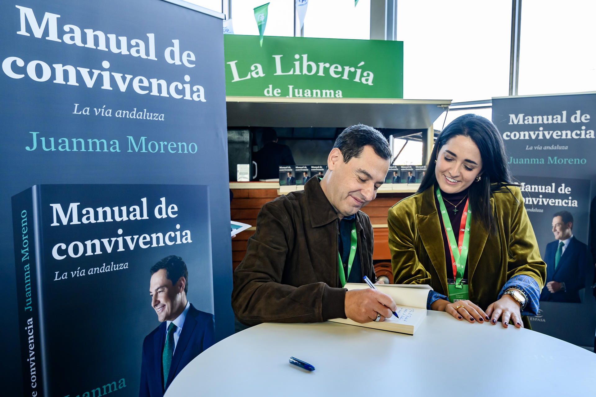 El presidente de la Junta, Juanma Moreno, firmando ejemplares de su libro en el Congreso Regional del PP.