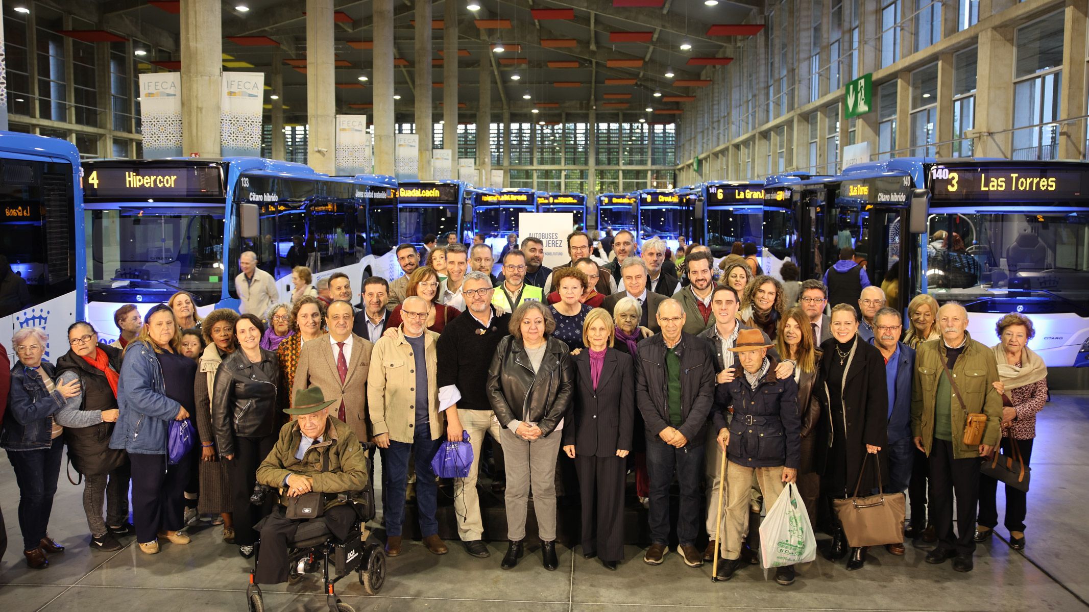 Foto de familia del gobierno, miembros de Comujesa y representantes de entidades, con los nuevos autobuses urbanos al fondo.