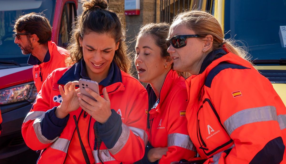 Operarias de emergencias observan fotos en el móvil de una de ellas durante el simulacro.