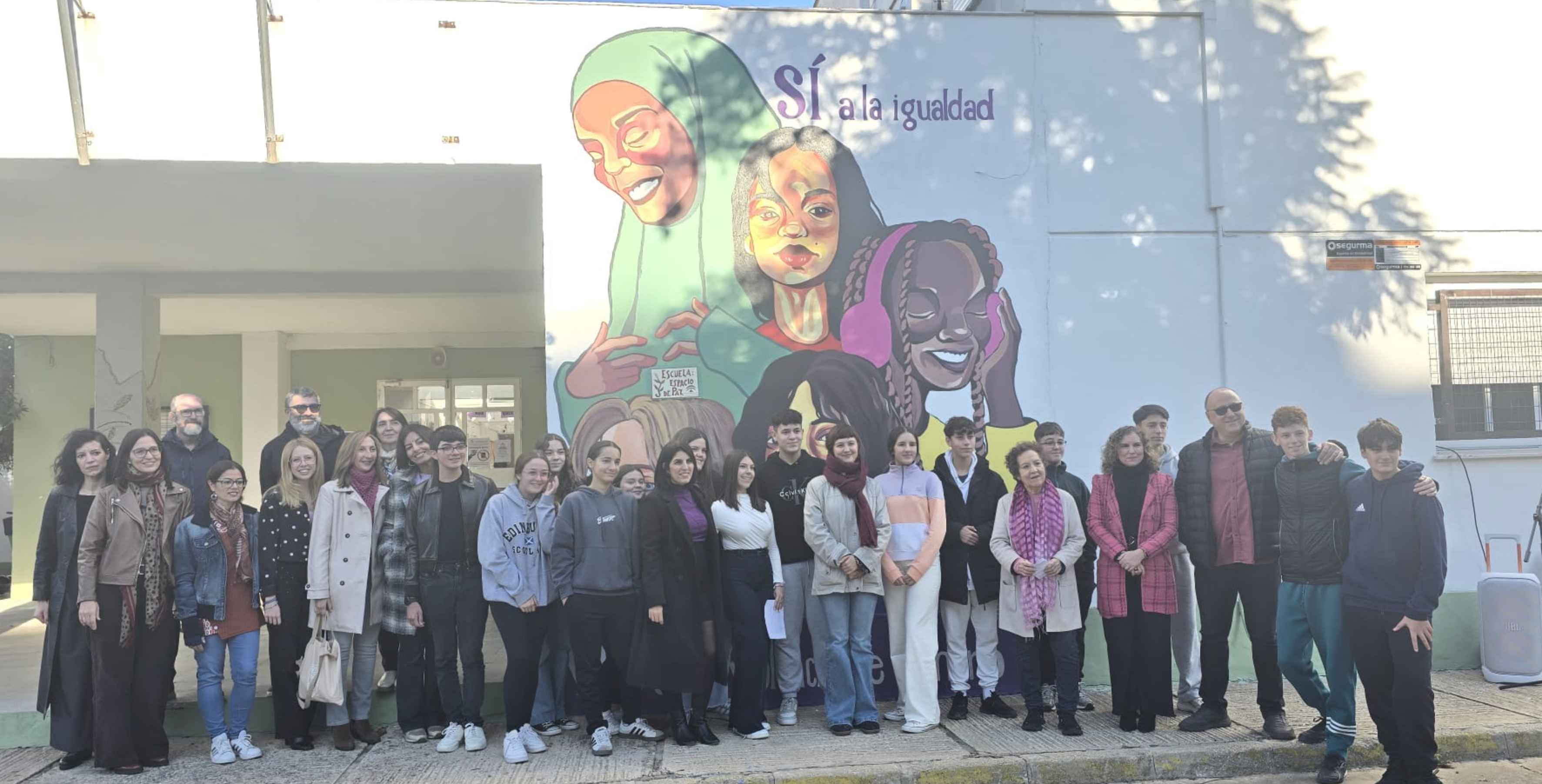 Alumnado y profesorado del IES Almunia junto al mural contra la violencia de género. 