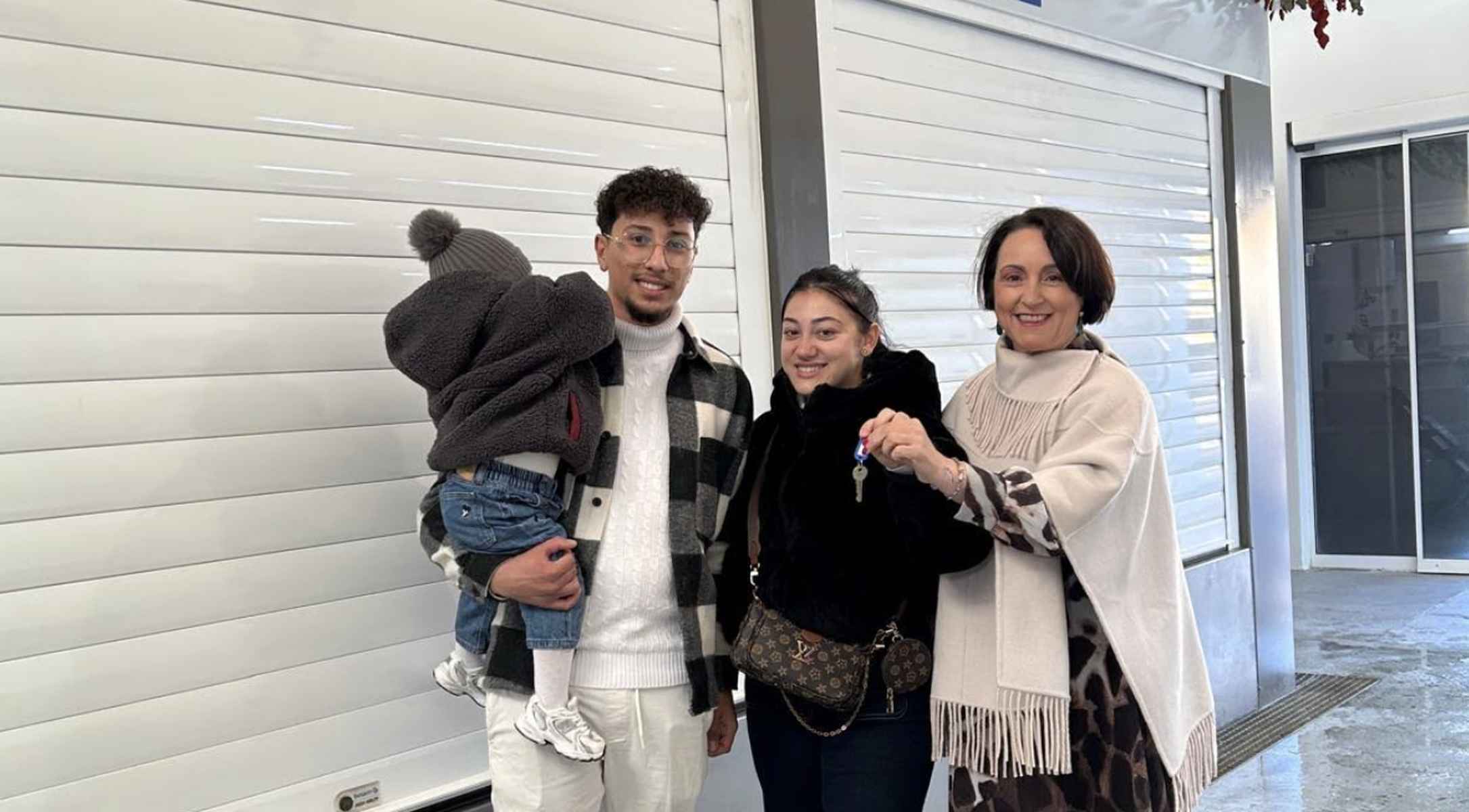 Los dos jóvenes reciben de manos de Nela García las llaves de la carnicería.