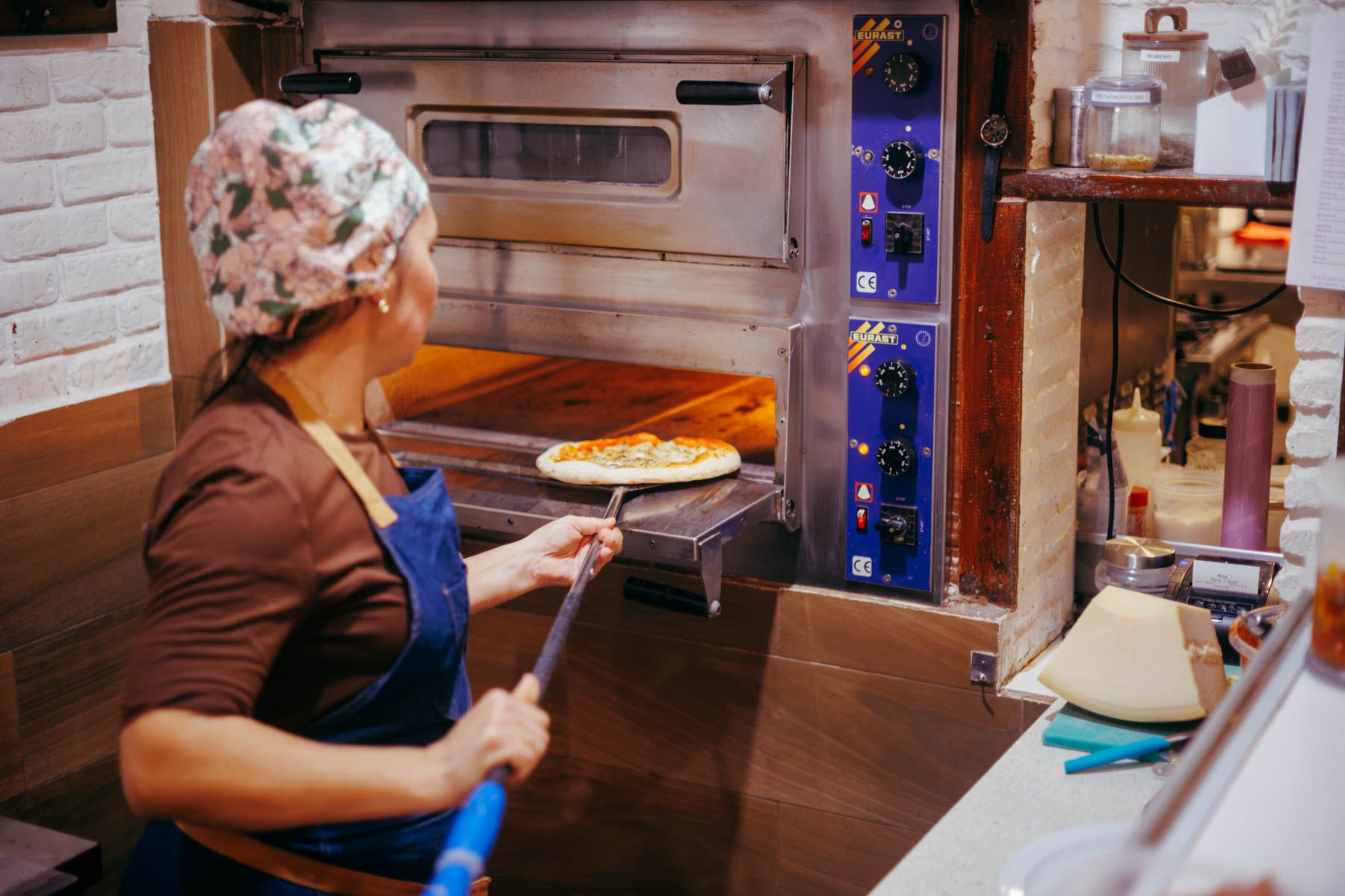 Introduciendo una pizza en el horno, uno de los aparatos de la cocina que más luz consumen.