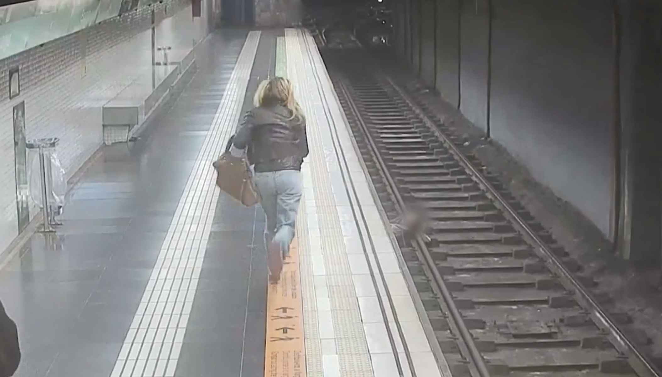 La agente, corriendo para salvar la vida del joven que había caído a las vías del metro.