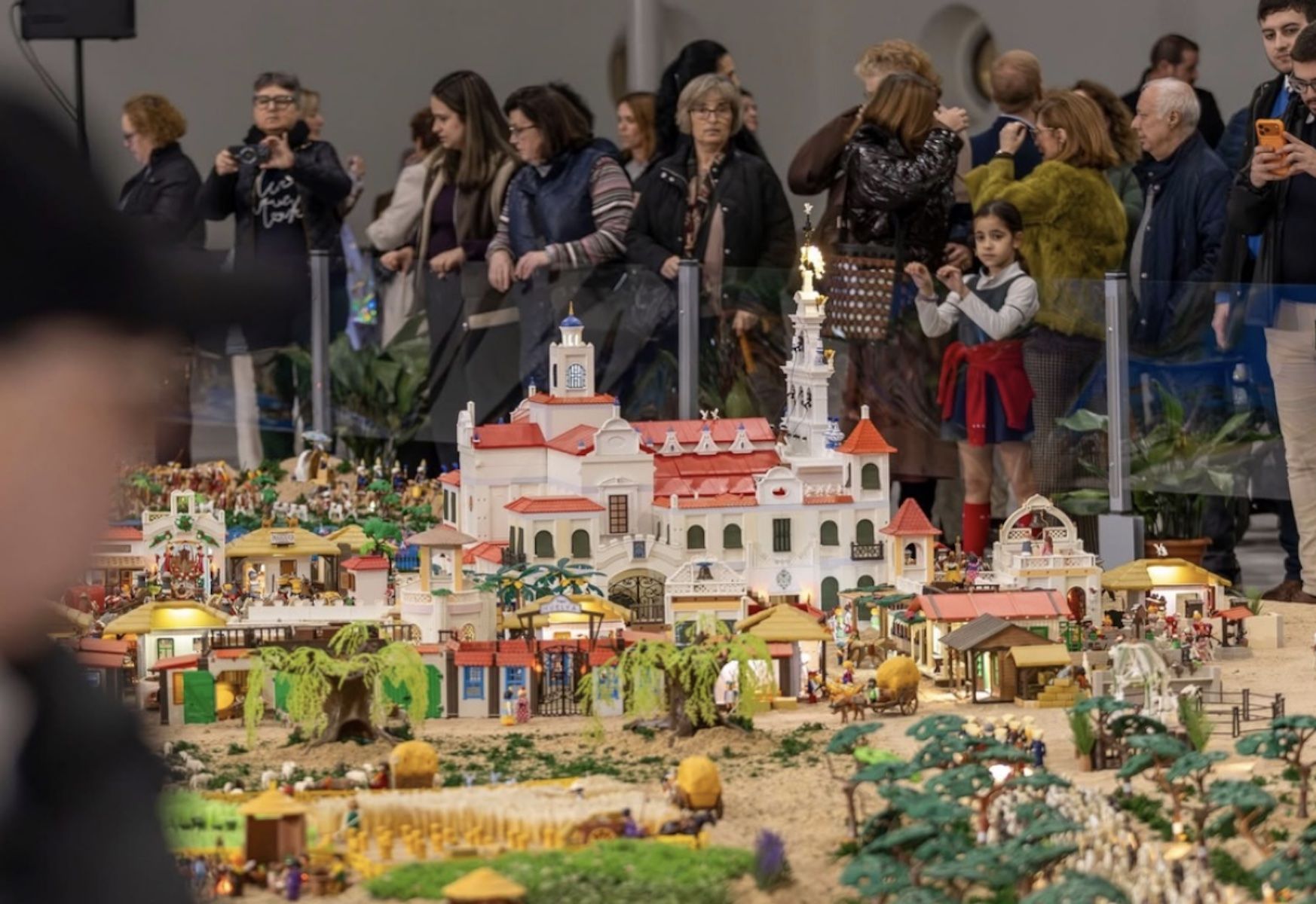 Ciudadanos observando el belén rociero de Huelva.