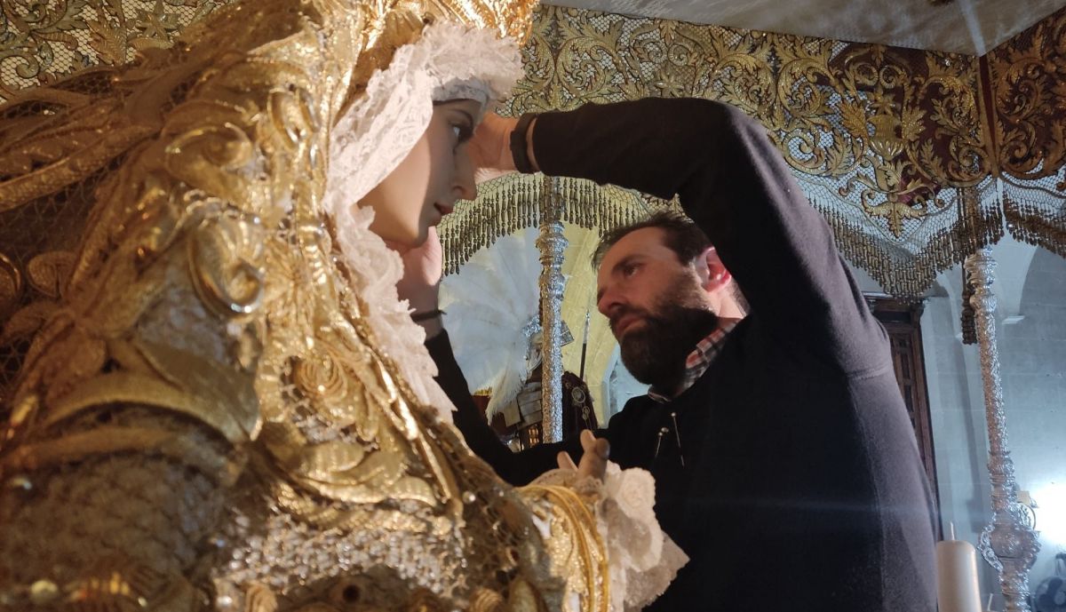 El vestidor ataviando a Madre de Dios de la Misericordia.
