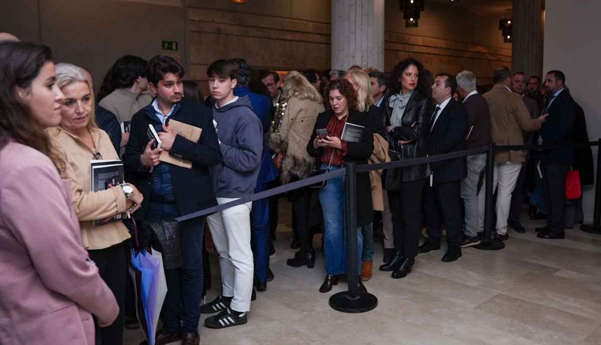 Gente esperando para llevarse la firma de Juanma Moreno en su libro.