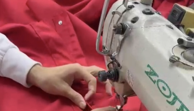 Una costurera de la empresa trabajando en un túnica.