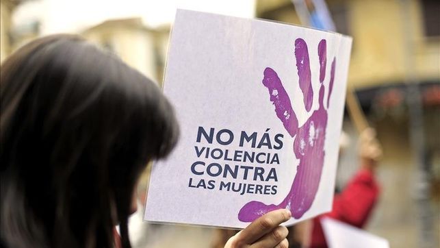 Una mano violeta en un cartel en una manifestación contra la violencia machista.