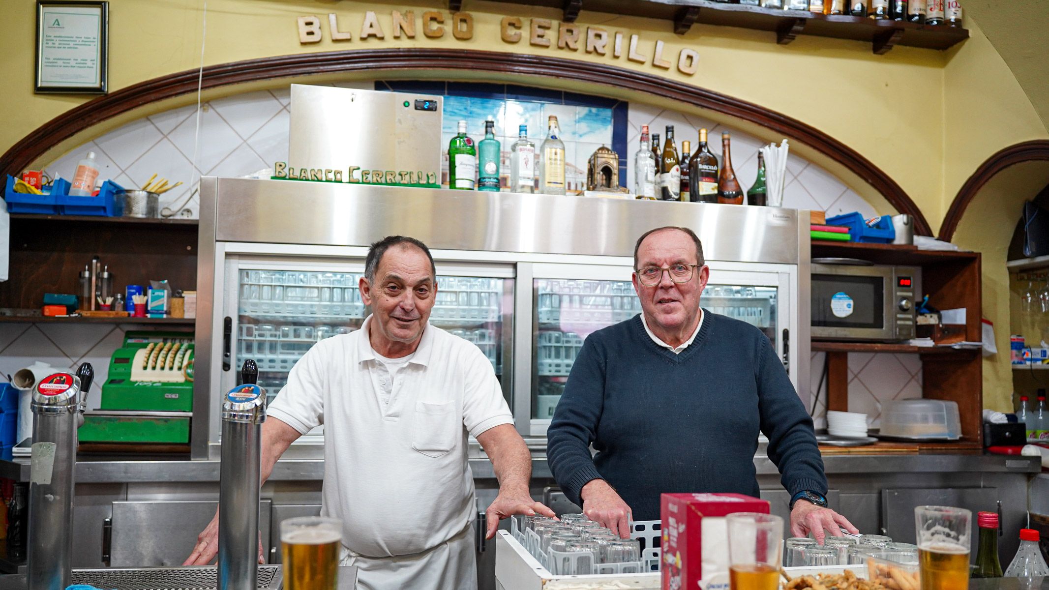 Paco y Pepe, camareros del Blanco Cerrillo, constituyen el haz y el envés del alma de este bar sevillano que ahora cumple un siglo.