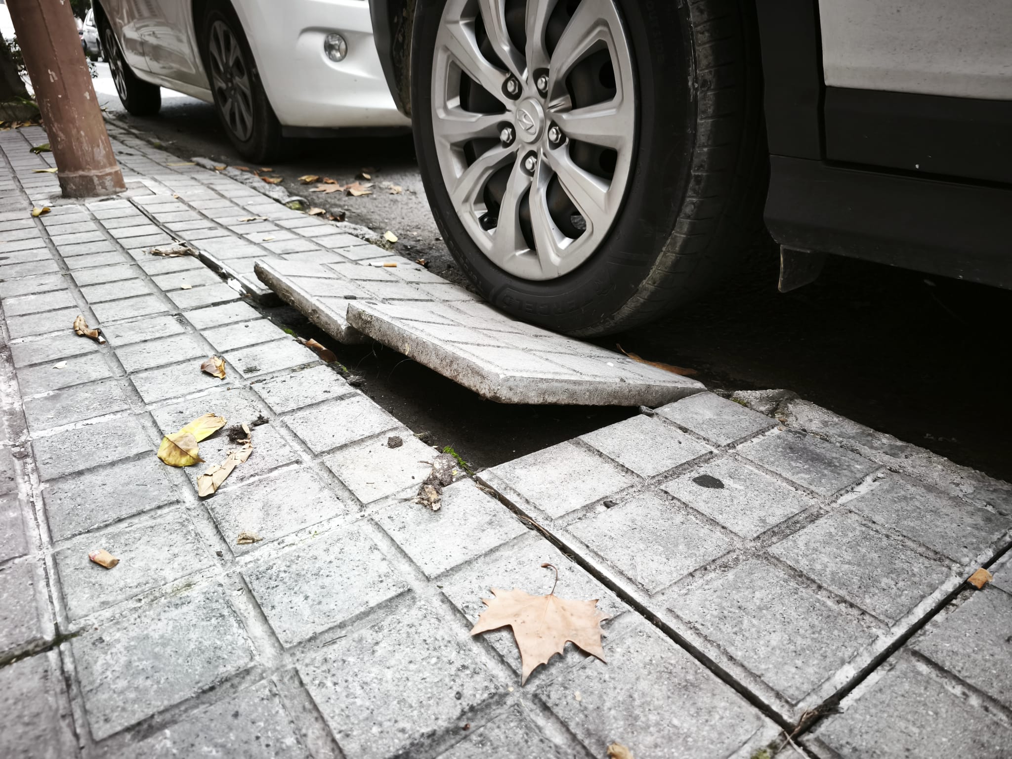 Una acera levantada tras aparcar un coche. Una acera levantada tras aparcar un coche.