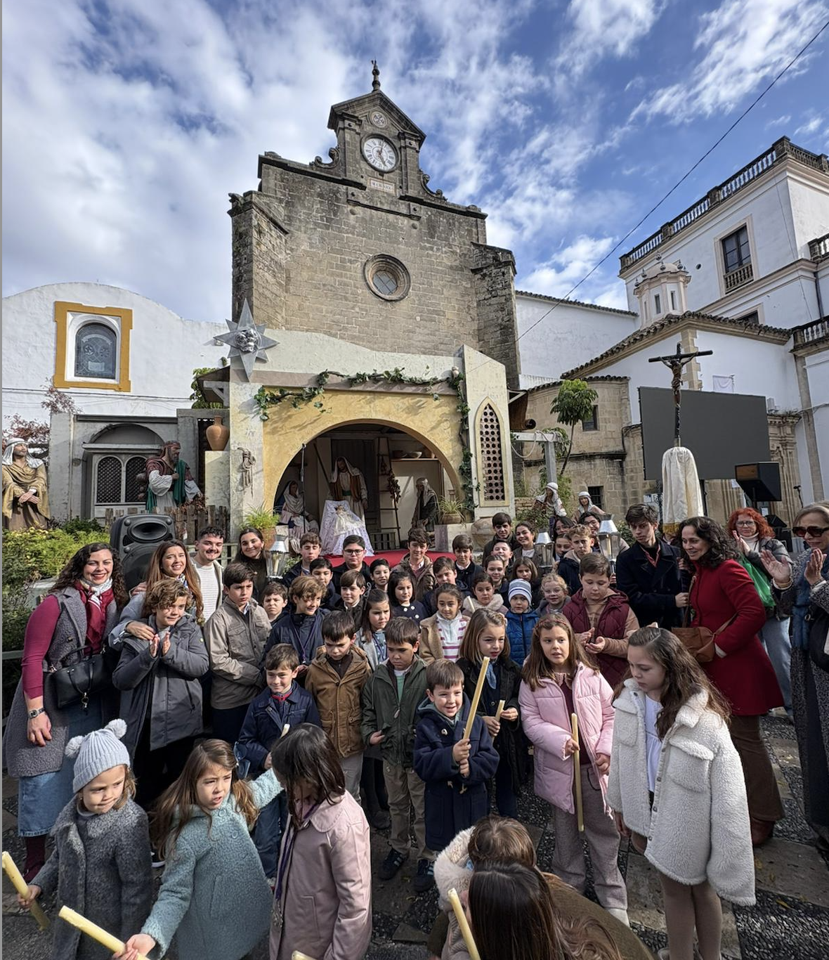 Los pequeños participantes posando ante del Belén monumental tras depositar en él al Niño Jesús. 