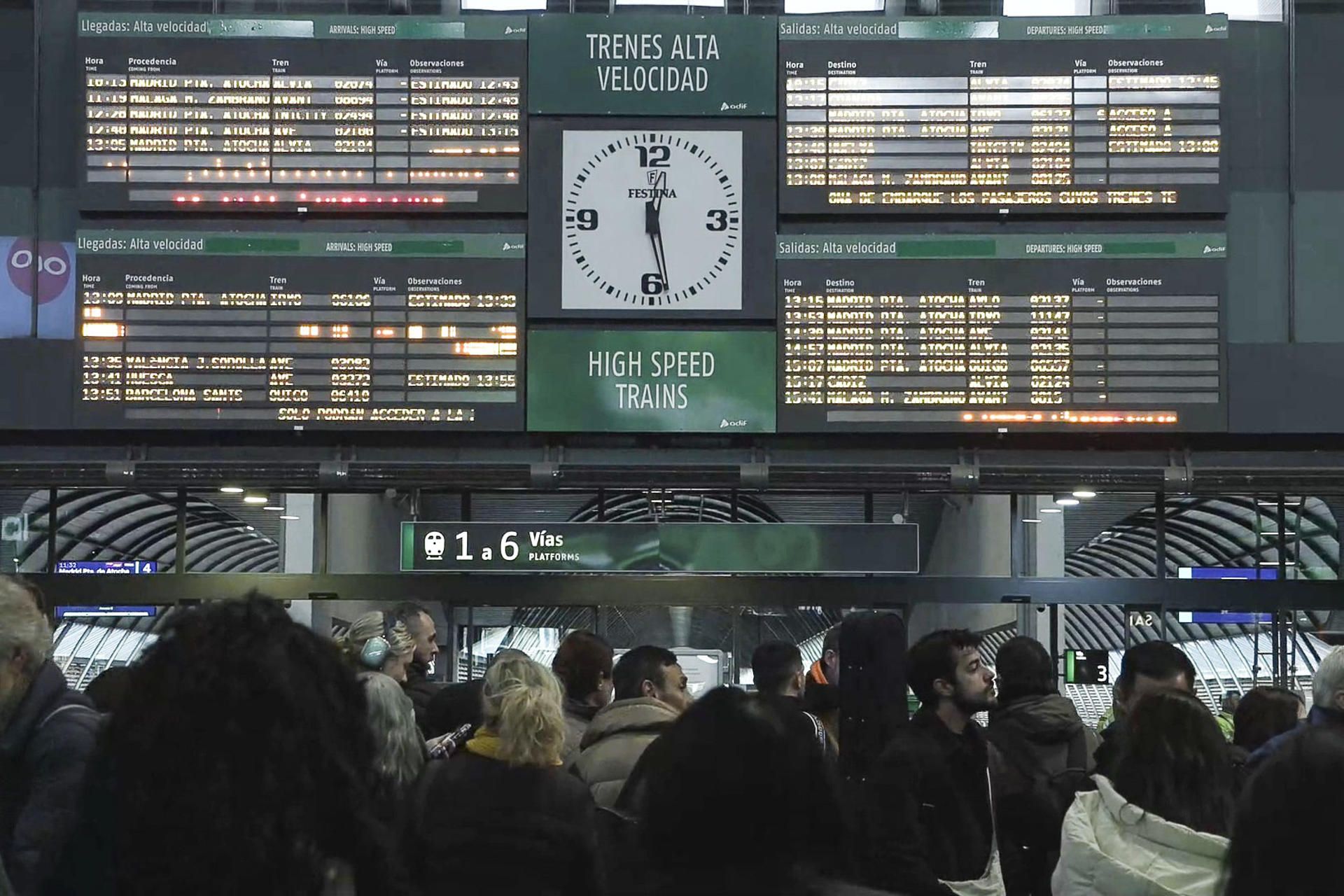 Pasajeros viendo los paneles con los horarios de los próximos trenes en Santa Justa.