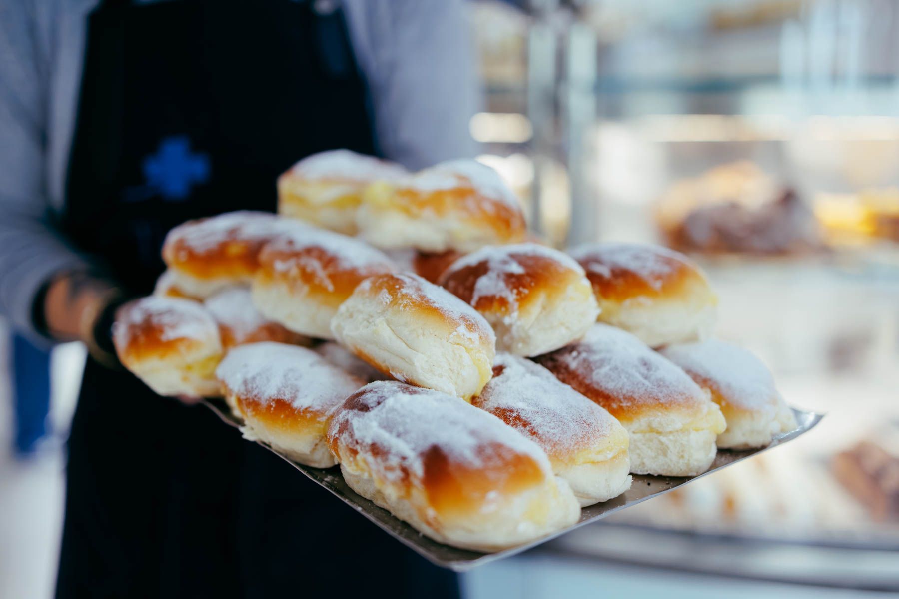 Una empleada de la cafetería Trébol sostiene una bandeja de carmelas.