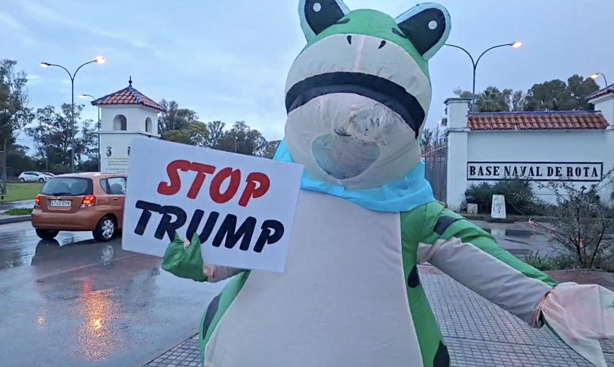 Un hombre, disfrazo de rana gigante, protesta contra Trump en la base naval de Rota.