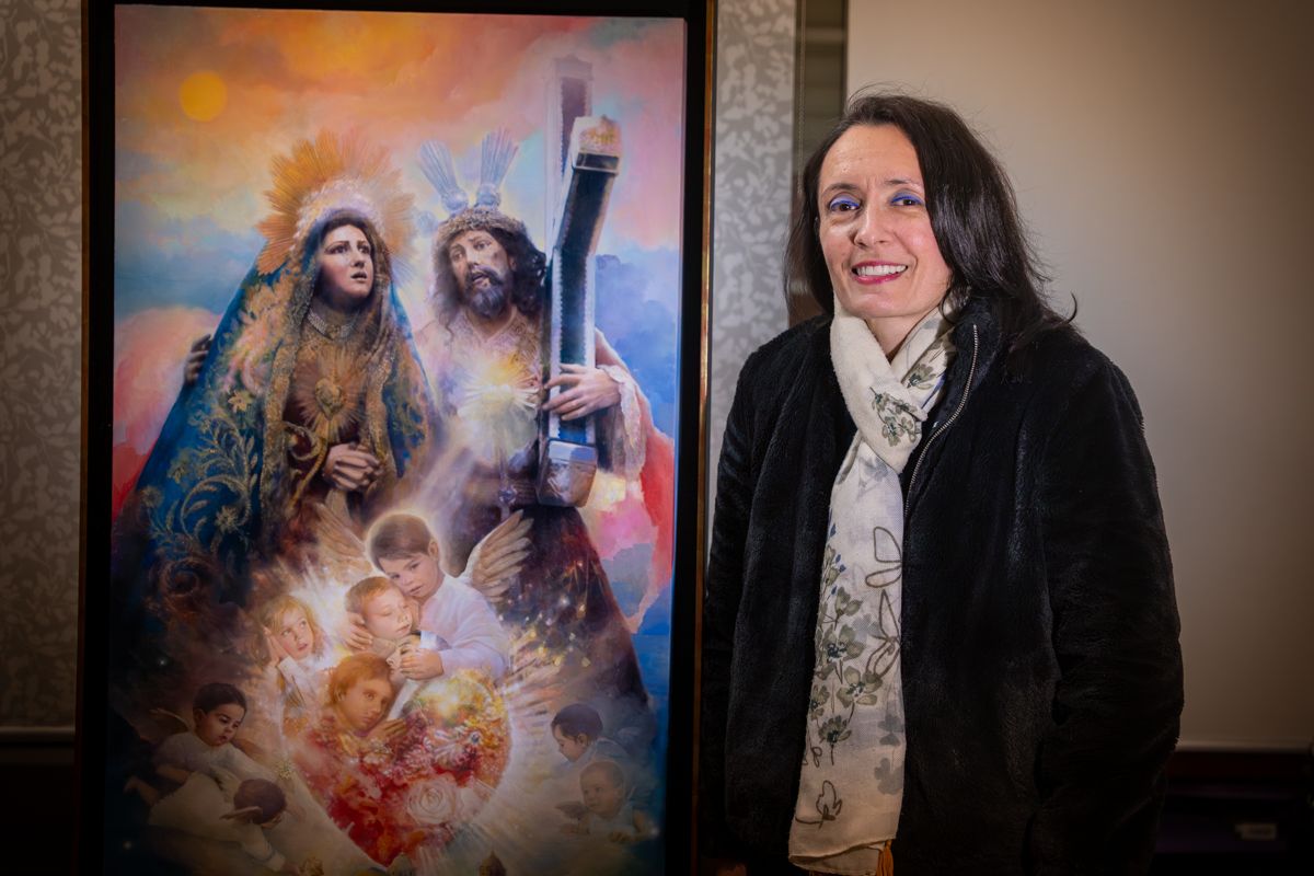 Isabel Sola en su estudioi junto al cartel que ha pintado para la Semana Santa de Cádiz. 