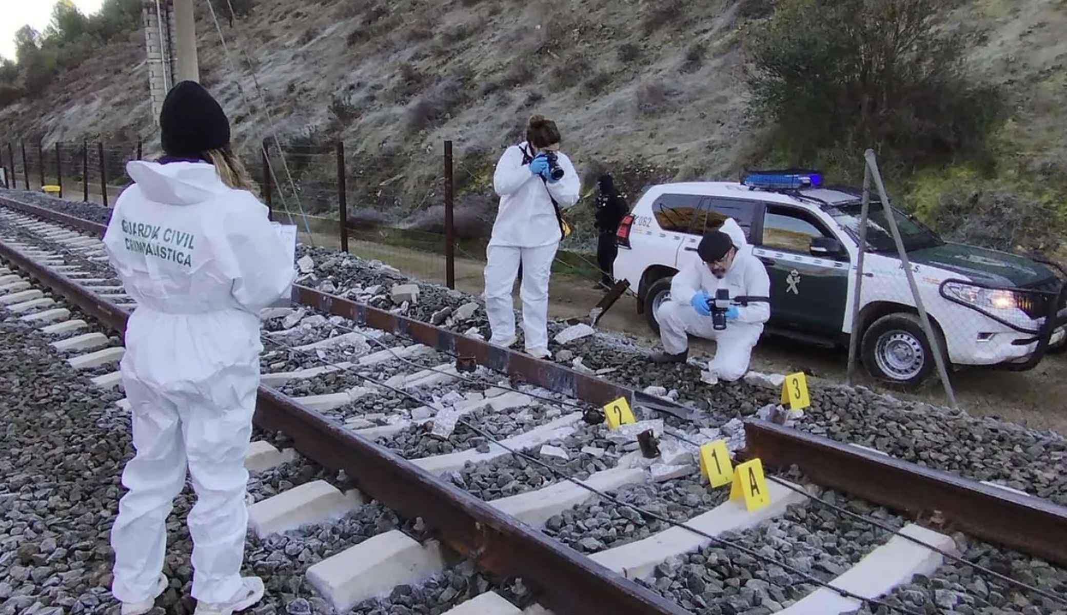 Agentes de Criminalística de al Guardia Civil fotografian la rotura de la vía.