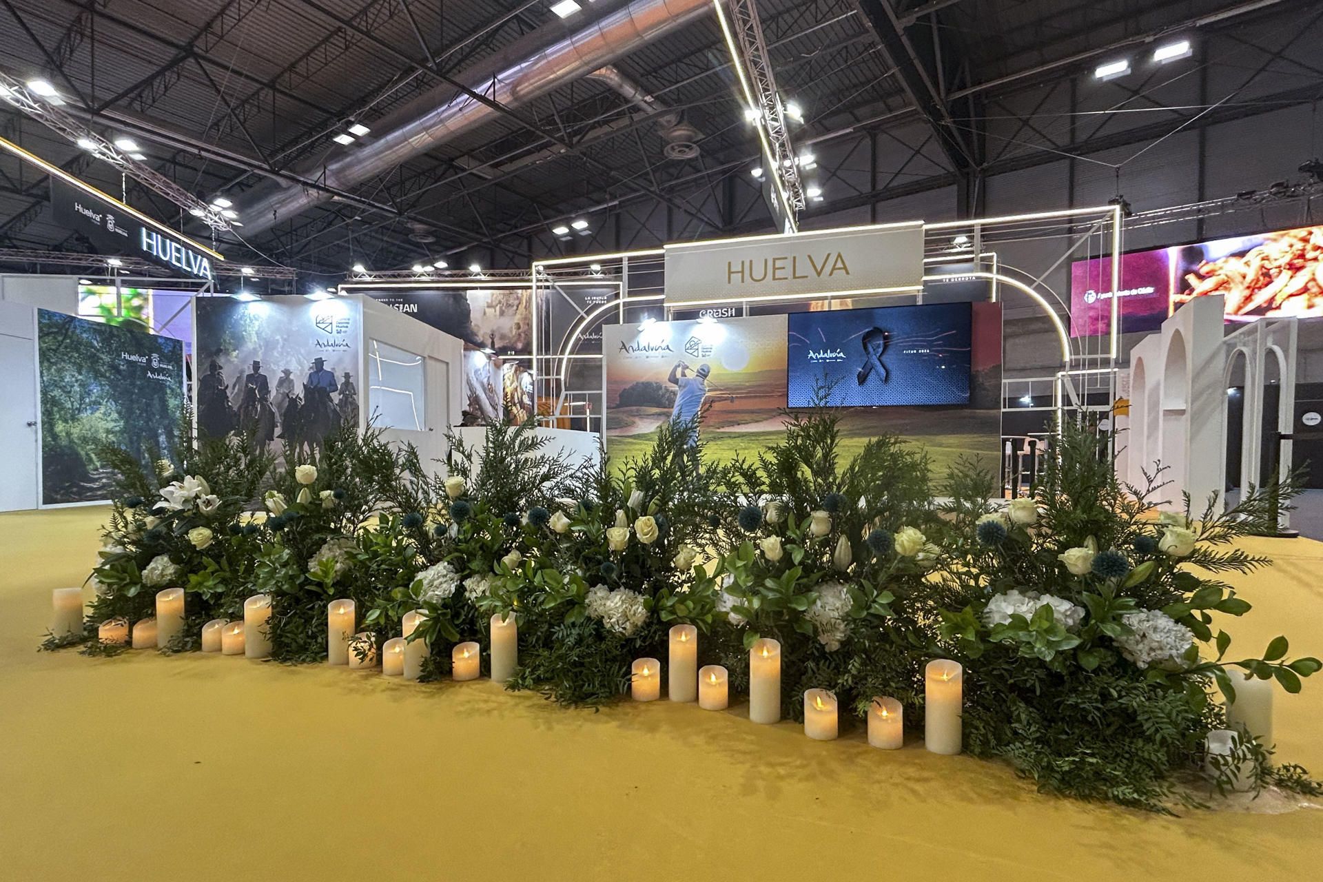 Flores y velas ante el stand de Huelva en la Fitur.