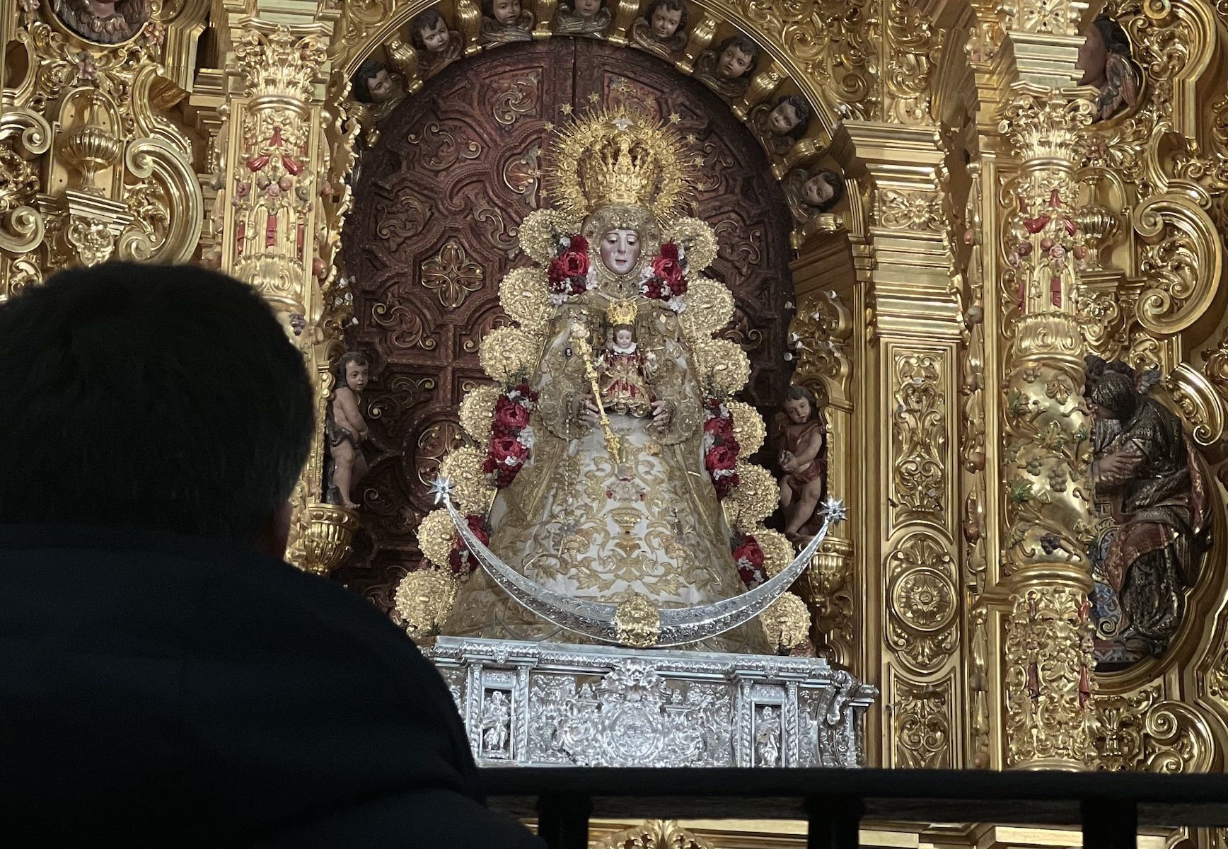 Un fiel rezándole a la Virgen del Rocío.
