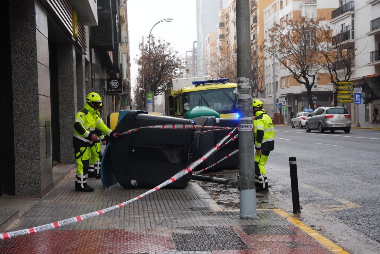 Bomberos en Cádiz retirando un contenedor de la carretera