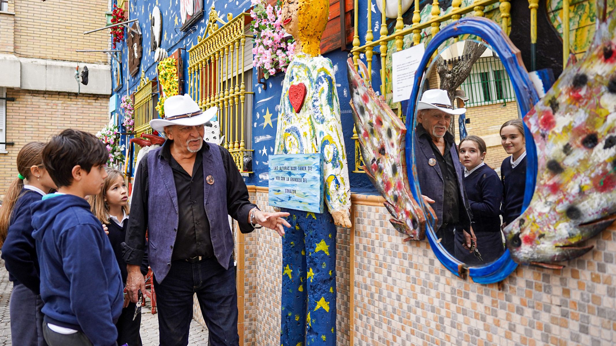 Manuel Salas, artista del barrio, explicando a los niños centro detalles de su casa museo.