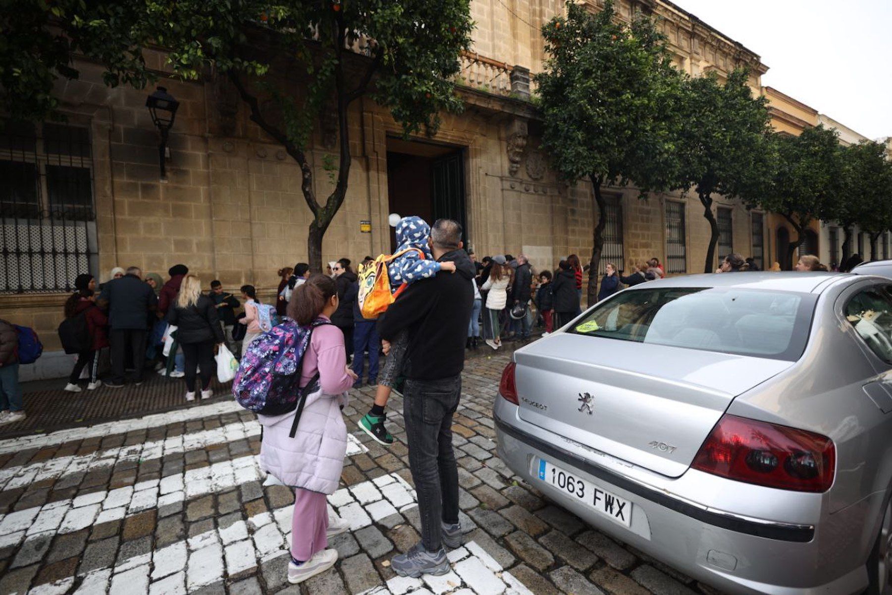 Las puertas el CEIP Miguel de Cervantes en Jerez abarrotada de padres recogiendo a sus hijos tras el anuncio de la suspensión de clases presenciales por el temporal.
