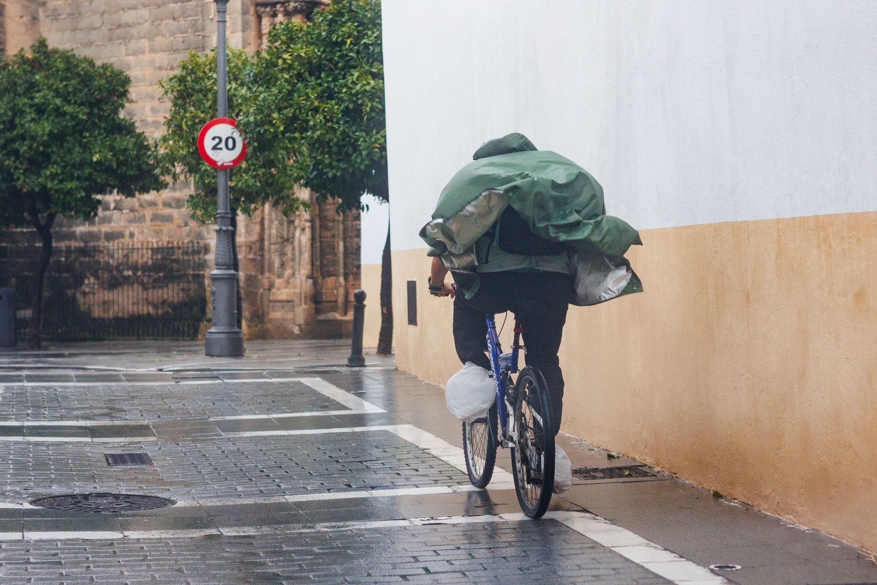 Una persona con la bicicleta bajo la lluvia en Andalucía.