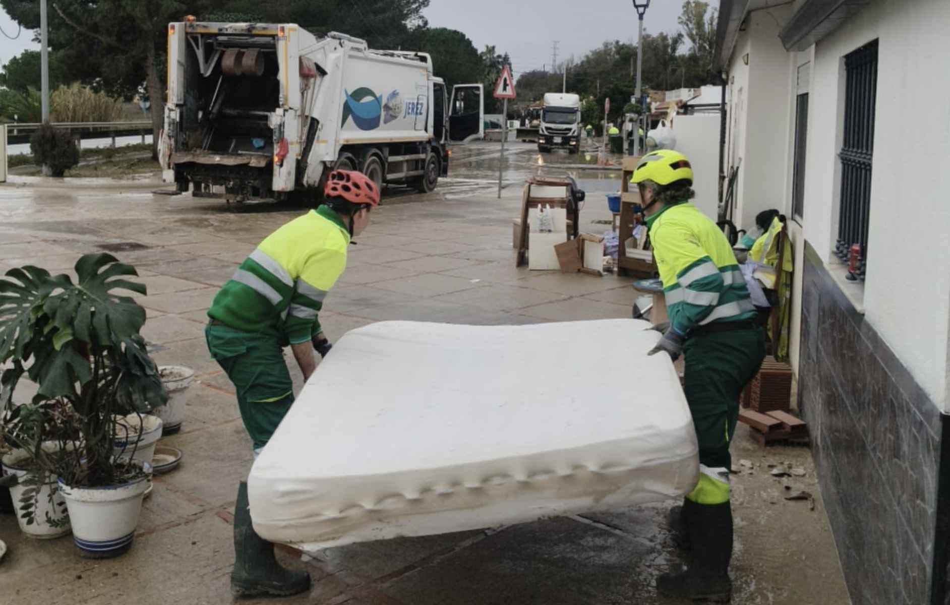 Trabajadores del servicio municipal de limpieza, transportando un colchón.