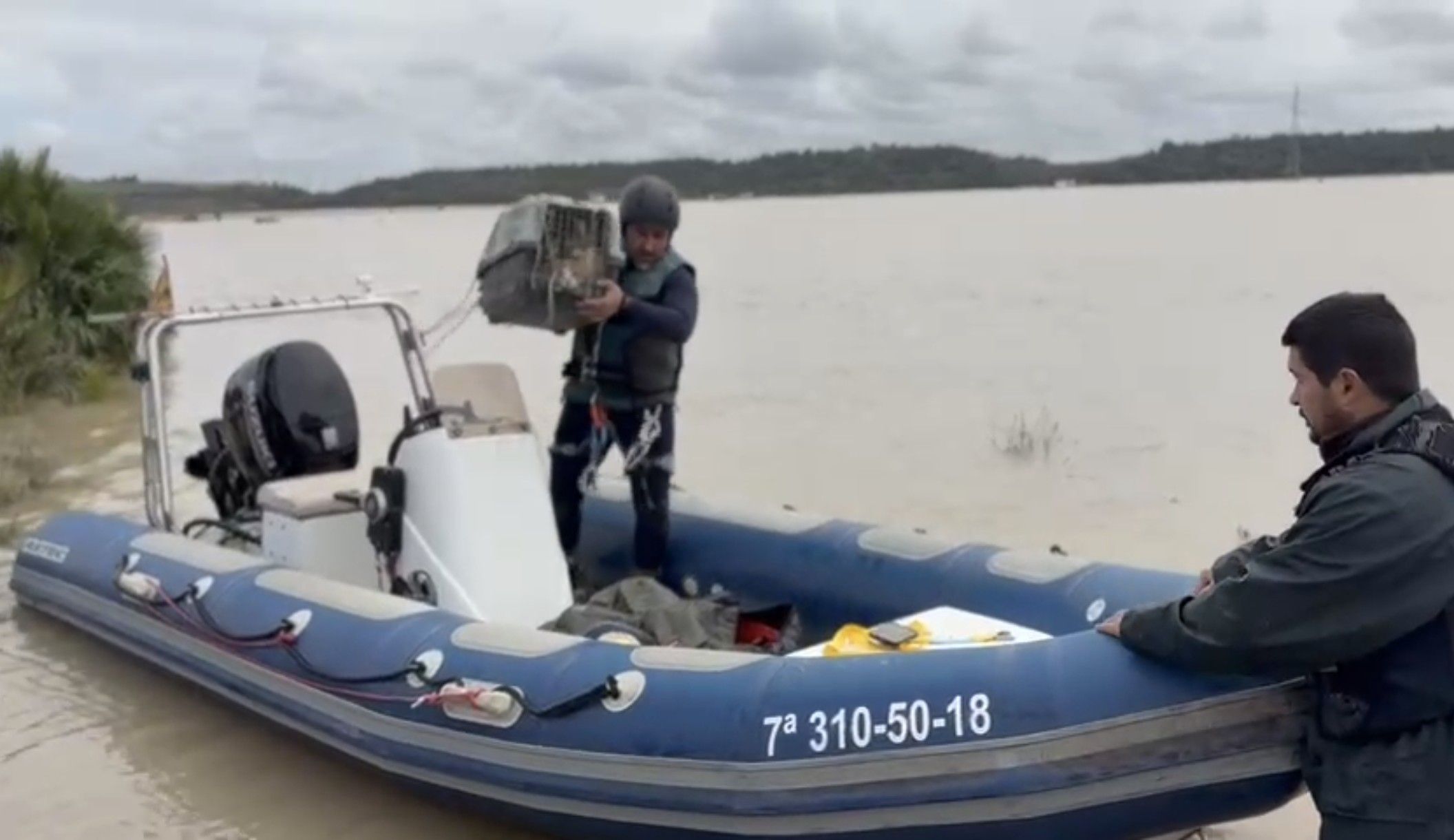 Vecinos de la zona salvando los gatos de una vivienda con una zodiac.