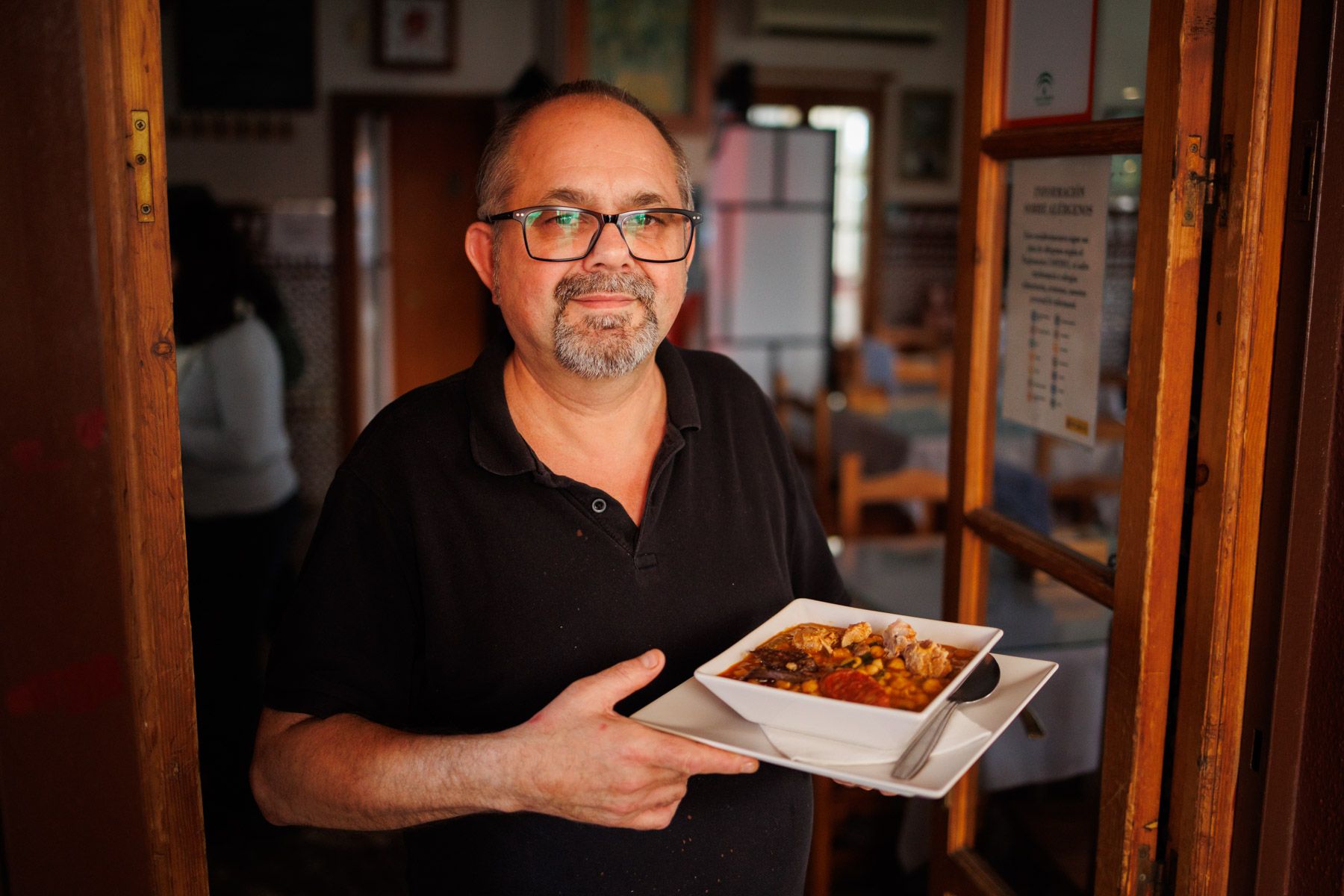 Fermín, propietario, del bar, con un plato de berza jerezana.